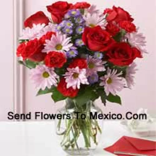 Roses rouges, oeillets rouges et gerberas roses avec des remplissages saisonniers dans un vase en verre - 24 tiges et remplissages