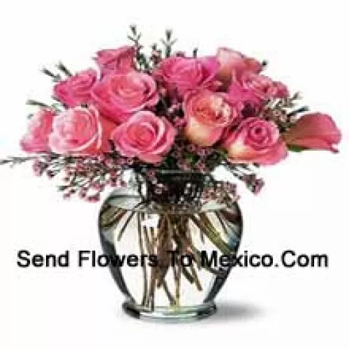 12 roses roses avec quelques fougères dans un vase