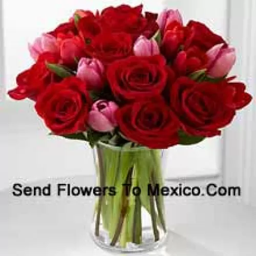 12 roses rouges et 6 tulipes roses avec quelques remplissages saisonniers dans un vase en verre